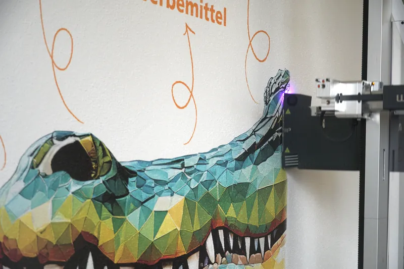 Detail des fertigen Motivs: die Druckfarbe folgt der Körnung der Rauputzwand